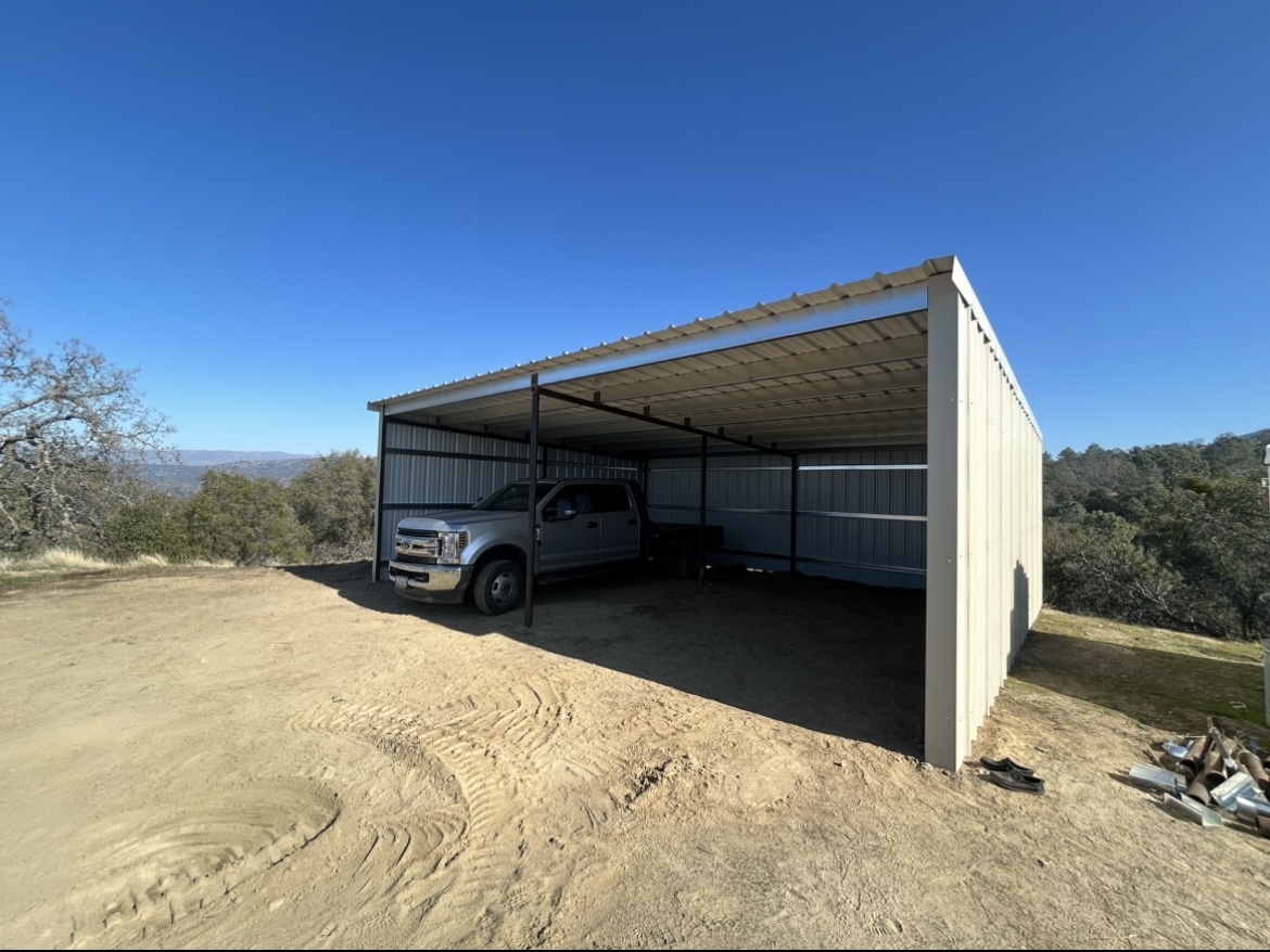 Steel-framed equipment shade cover with metal roofing and back wall