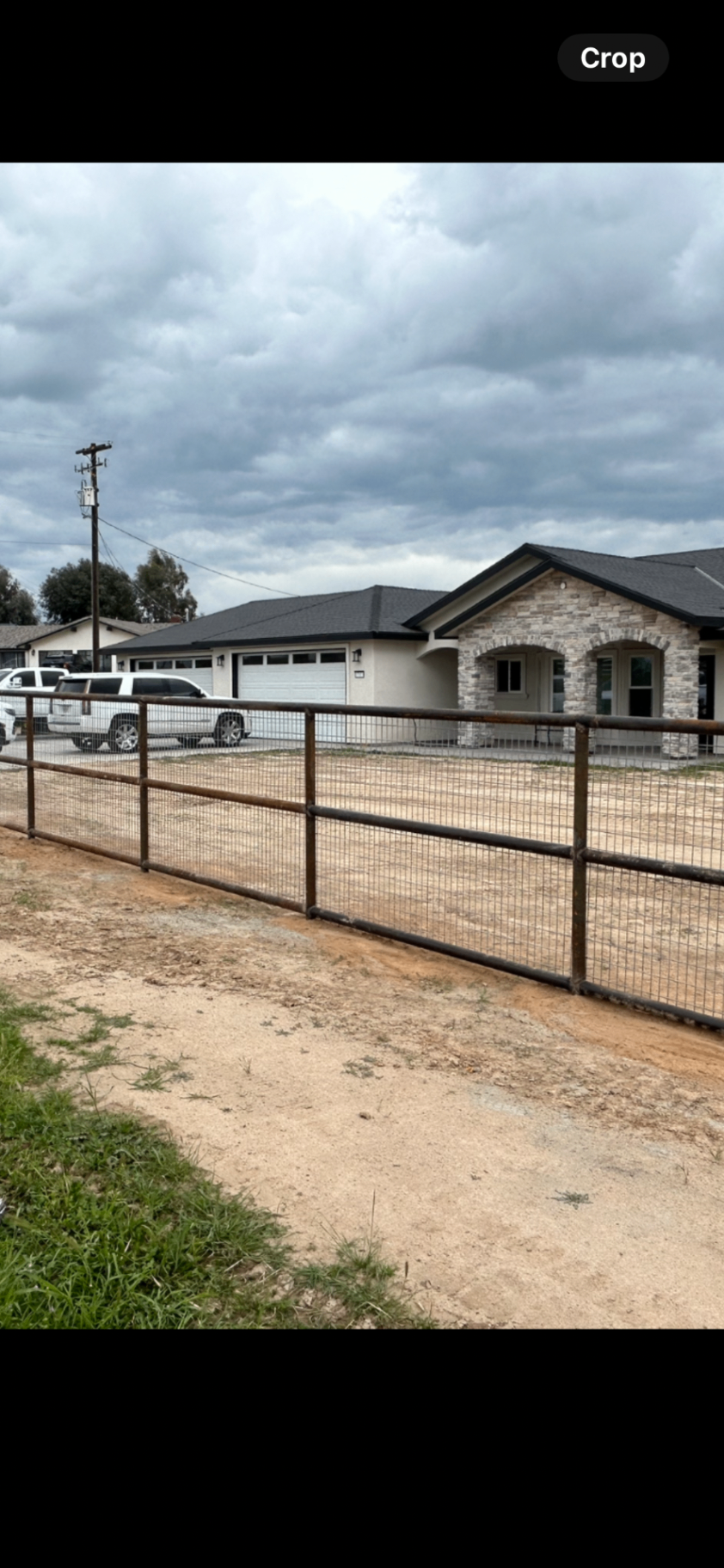 Pipe rail and wire mesh front yard fence at a Valley ranch home